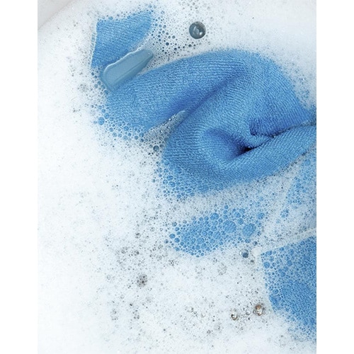 Blue cloth soaking in soapy water with suds